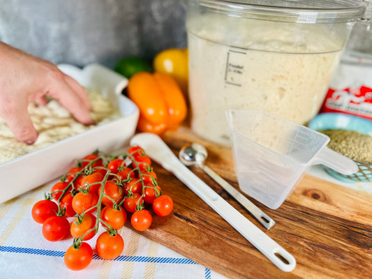 A kitchen scene featuring ingredients for making focaccia bread